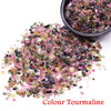 A pile of colorful tourmaline crystal stone chips in various shades and sizes.