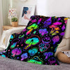 A colorful mushroom print flannel throw blanket displayed on a light-colored sofa.