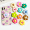 A collection of colorful, flower-shaped silicone grips for a foldable phone, displayed on a white background.