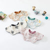 A collection of soft, patterned cotton baby feeding bibs and a small stuffed animal