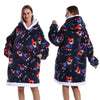 Eine Frau präsentiert einen marineblauen Patchwork-Fleece-Hoodie mit weißer Sherpa-Futter und roten Akzenten.