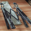 A pair of black foldable aluminum laptop stands are shown resting on a wooden surface.