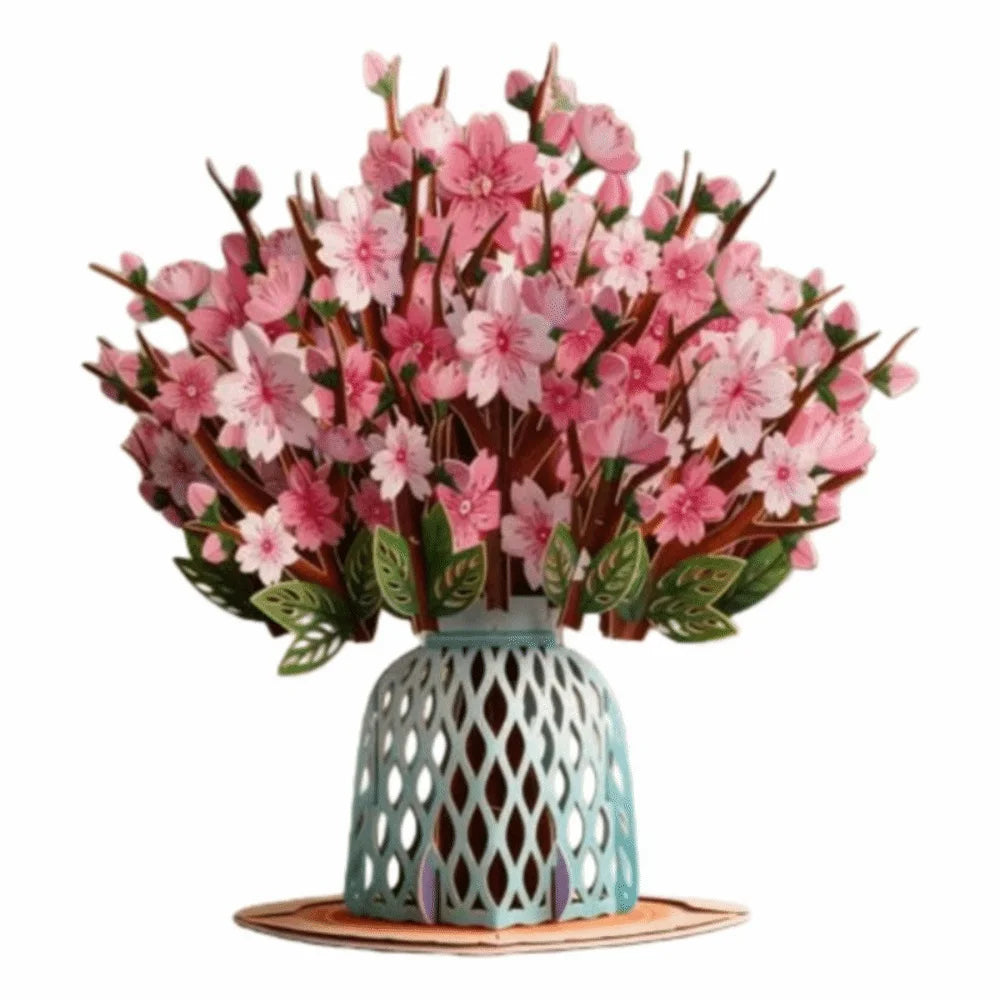 A bouquet of pink cherry blossoms arranged in a teal ceramic vase on a wooden coaster.