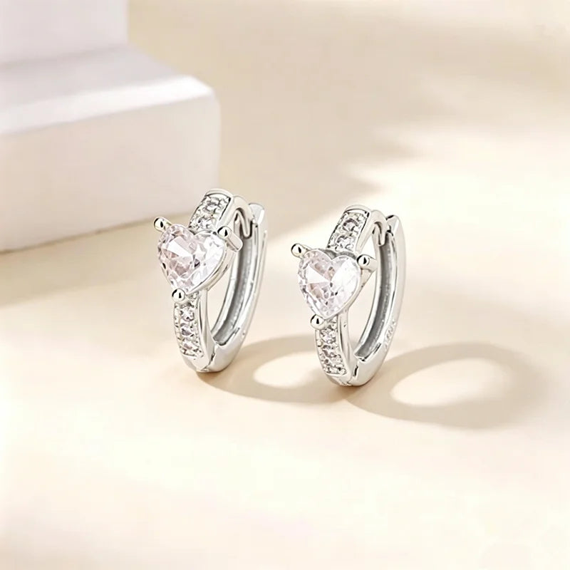 Pendientes de aro plateados con piedra de circonita en forma de corazón y diamantes engastados.
