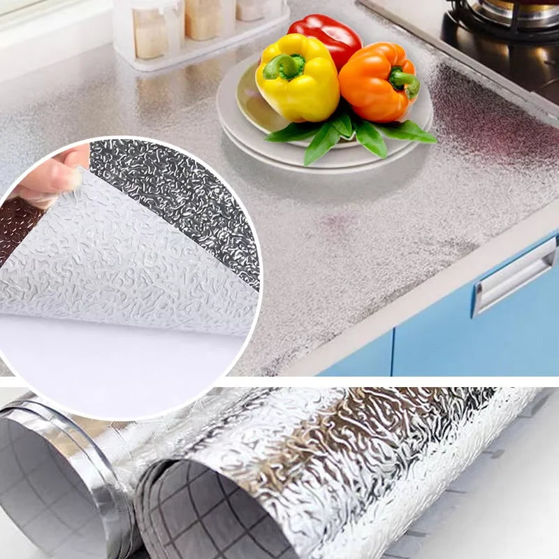 Self-adhesive aluminum foil kitchen backsplash protector showing various textures and a roll of protective film.