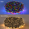A close-up view of solar powered LED string lights with multicolored bulbs illuminating a dark background.