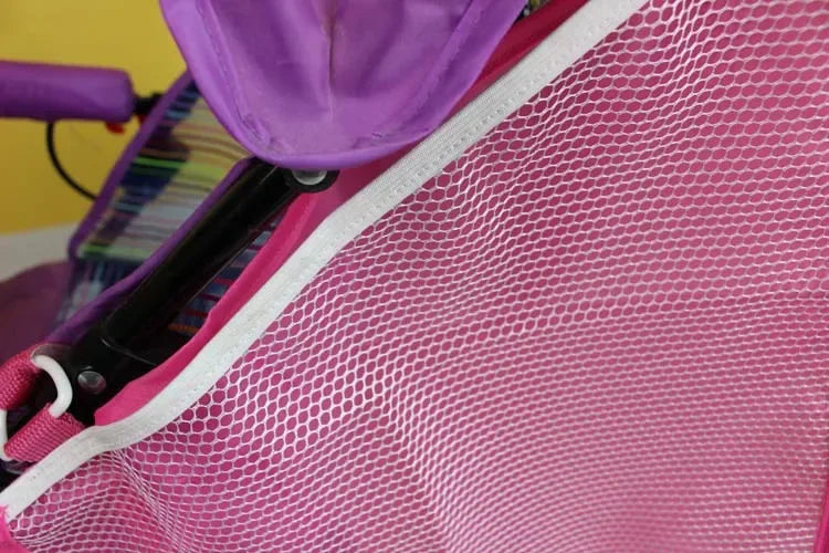 A pink mesh organizer for a stroller, featuring purple fabric and white trim.