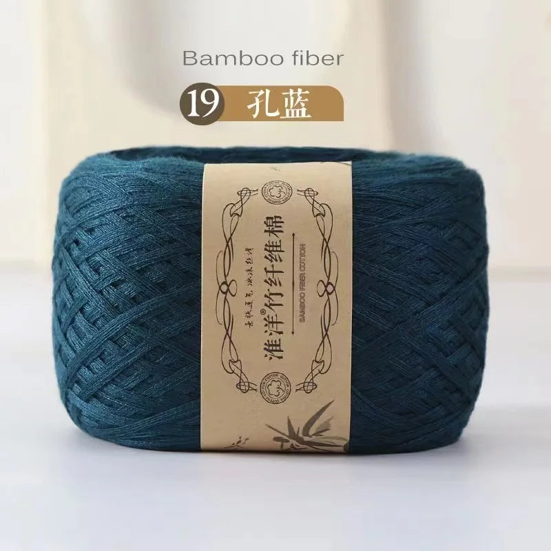 A ball of dark teal bamboo fiber yarn labeled as 19 扎蓝, ready for knitting or crochet.
