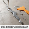A close-up of a thick, gray self-leveling crack sealant dripping down a concrete surface next to an orange spatula.