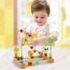 A young boy is playing with a wooden bead maze toy featuring colorful beads and wooden components.