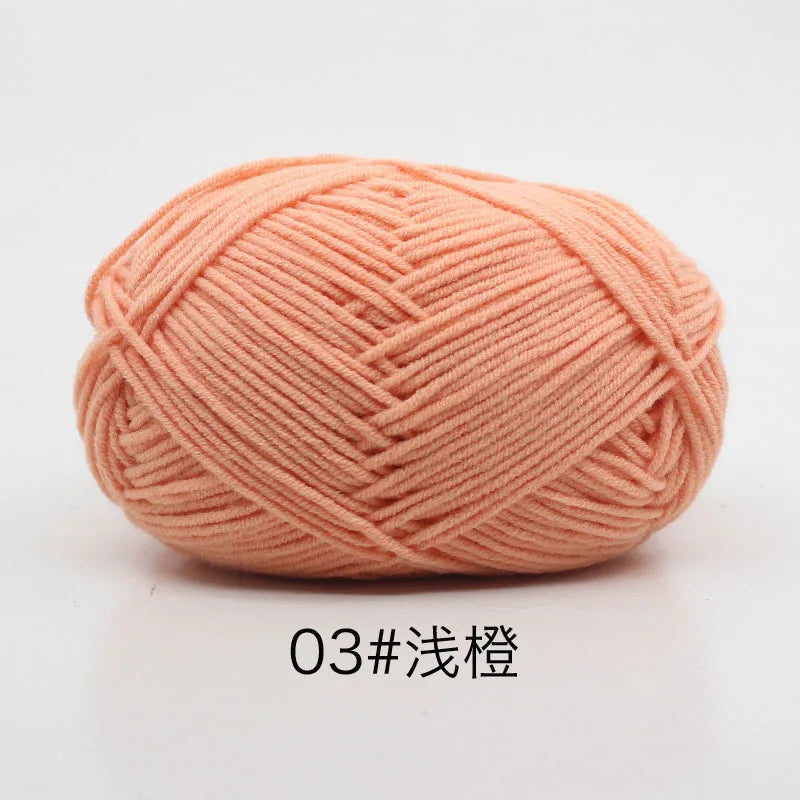 A ball of soft, peach-colored 4-ply milk cotton yarn for knitting and crochet.