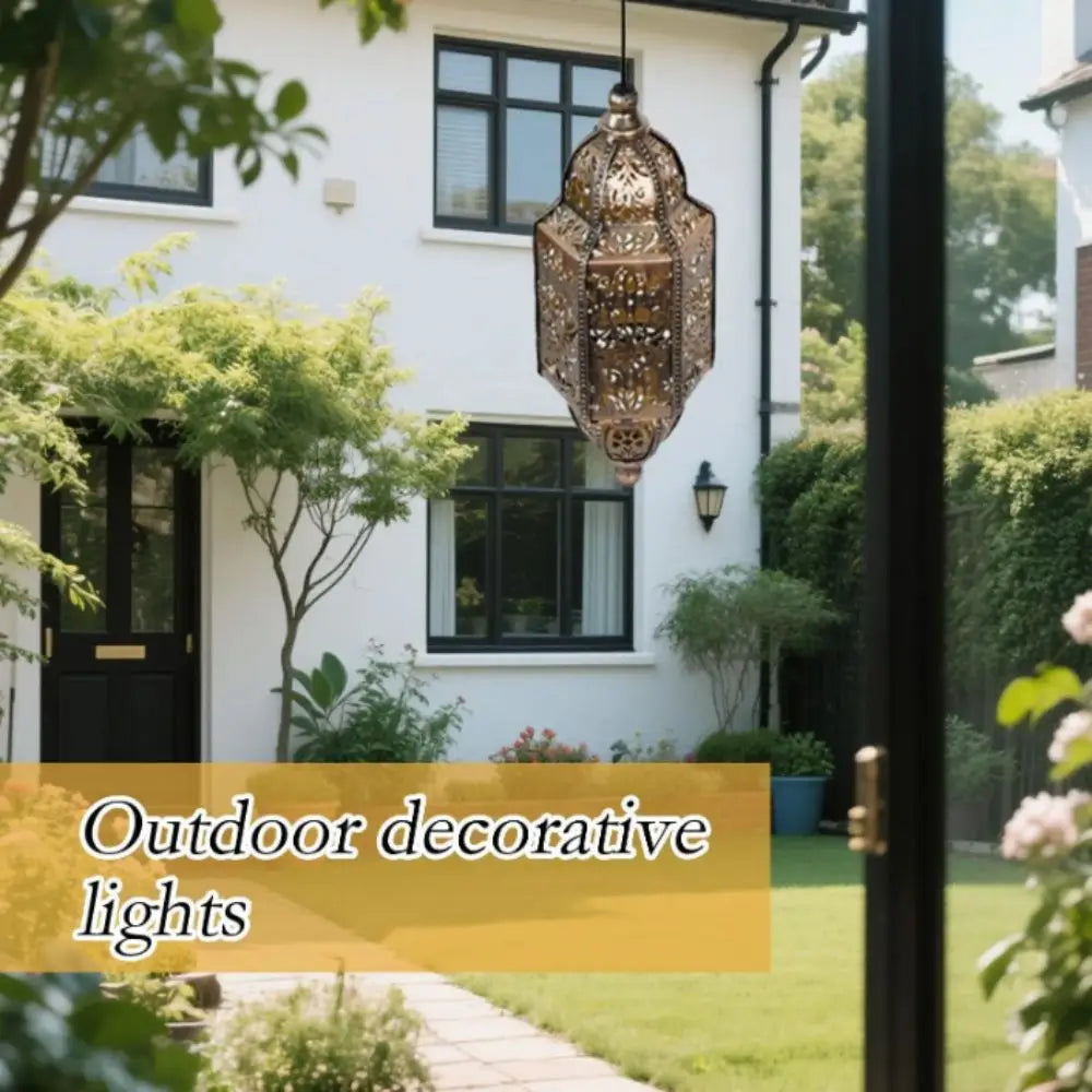 A decorative solar-powered Moroccan lantern with waterproof ironwork hanging on a white house facade.