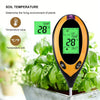 An orange soil temperature meter with a digital display measuring 28 degrees Celsius, placed among green plants.