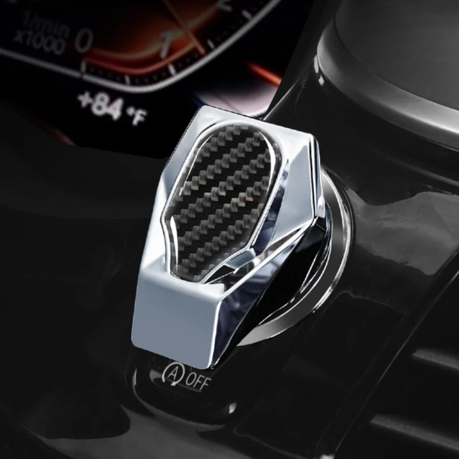 Close-up of a silver metal button cover and engine switch decal for a car interior