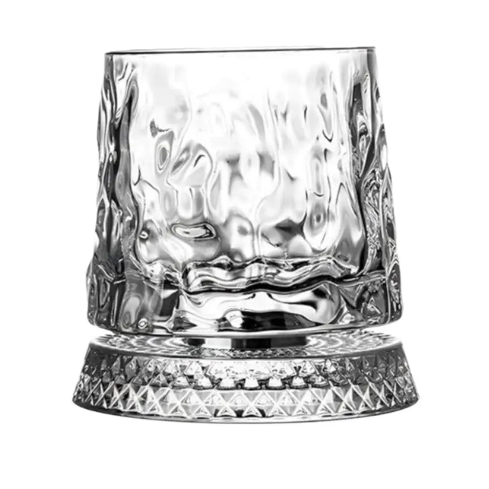 A clear crystal whiskey glass with a textured, swirling pattern sits on a round base.