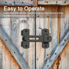 A black stainless steel flip barn door lock is shown mounted on a weathered wooden door.