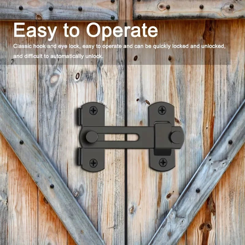 A black stainless steel flip barn door lock is shown mounted on a weathered wooden door.