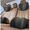 A tan car seat interior showing memory foam headrests and lumbar support pillows in gray.