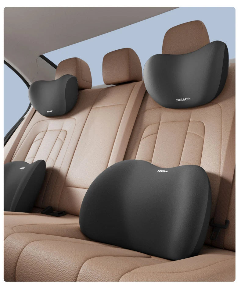 A tan car seat interior showing memory foam headrests and lumbar support pillows in gray.