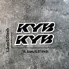 Black and white KYB motocross motorcycle fork stickers displayed on a gray textured surface.