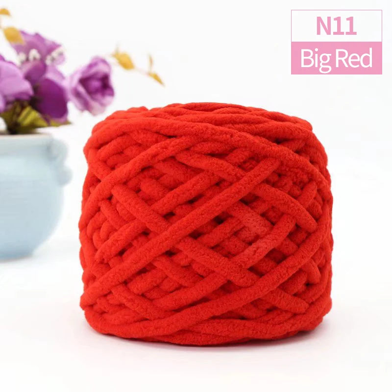A ball of bright red chunky chenille yarn used for knitting and crochet projects.