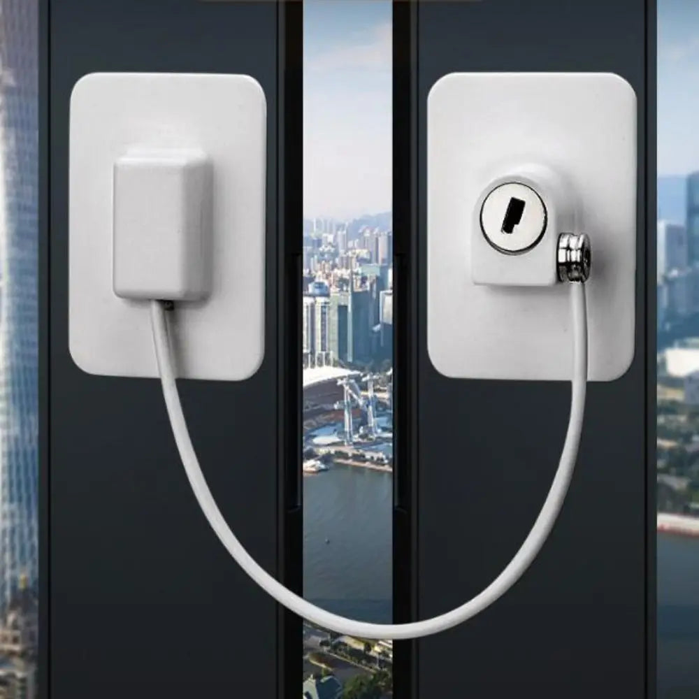 A white window safety lock with two keys is mounted on a dark door frame, featuring a long white cord.