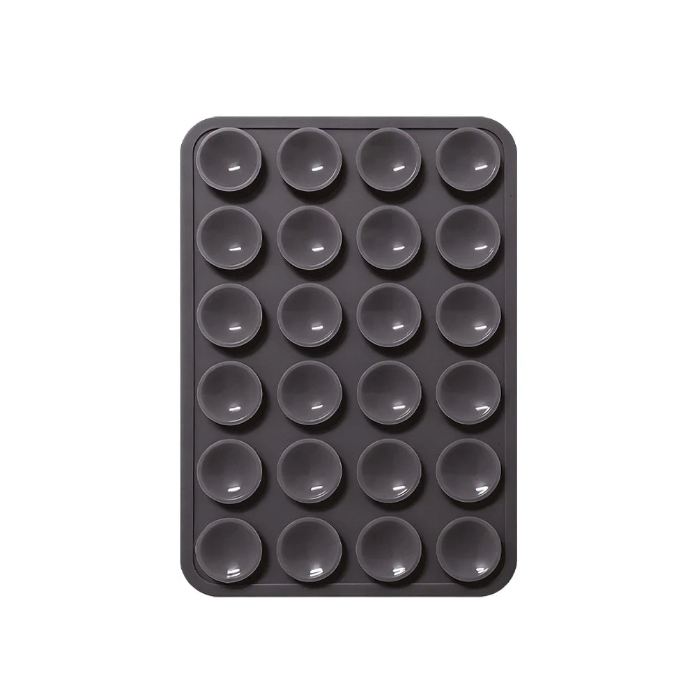 A black silicone suction pad with multiple circular indentations for phone mounts.
