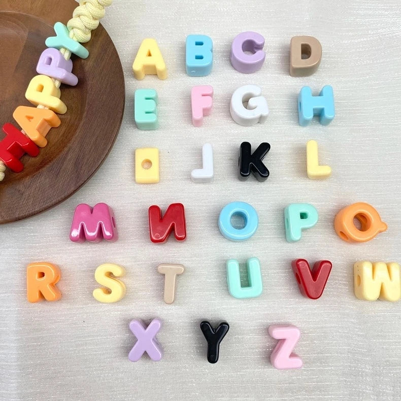 Collection de perles de lettres acryliques colorées, arrangées par ordre alphabétique pour la fabrication de bijoux DIY
