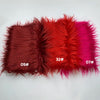 A swatch of soft faux fur fabric in shades of deep red, orange-red, and magenta.