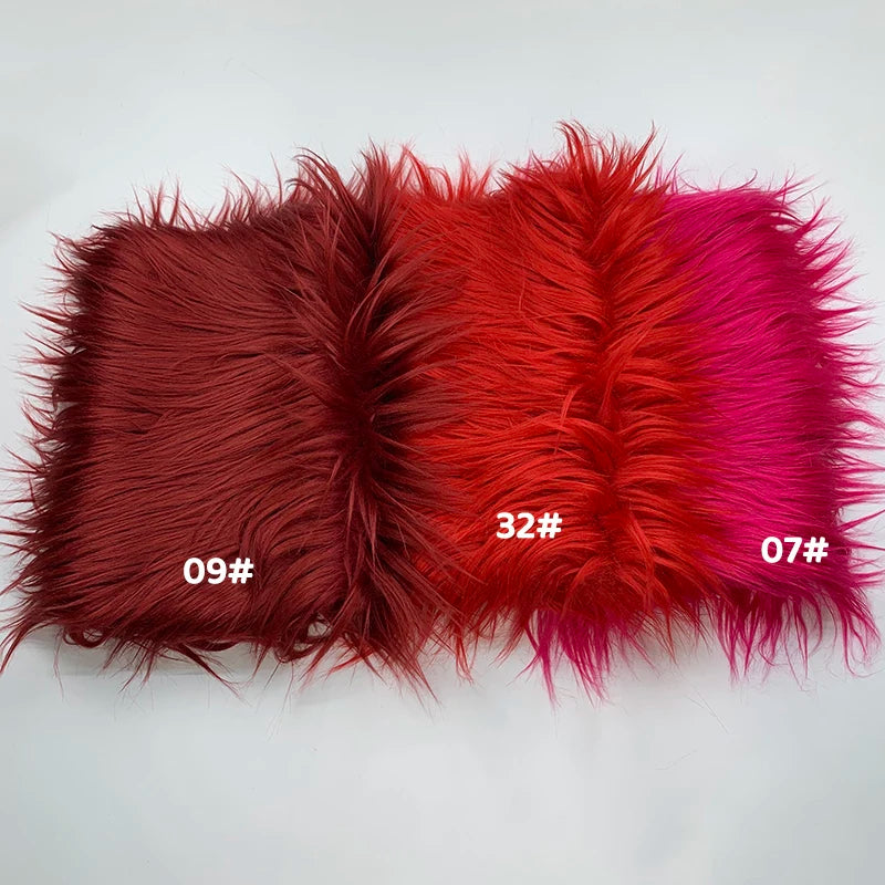 A swatch of soft faux fur fabric in shades of deep red, orange-red, and magenta.