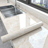 Marble peel-and-stick wallpaper used as a decorative element on a kitchen countertop.