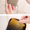 A close-up of a brown accordion wallet with a protective RFID shield being held by a hand.