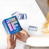 Hands hold a box of Drink IF adult drinking game cards next to a separate card.