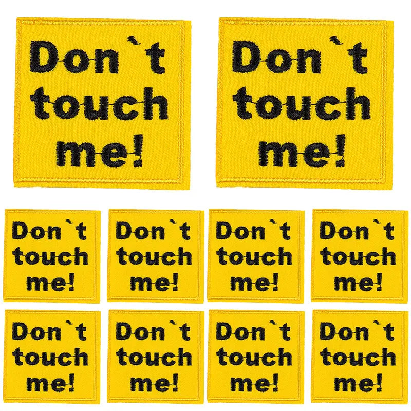 Ten yellow iron-on patches with black text saying Don't touch me!