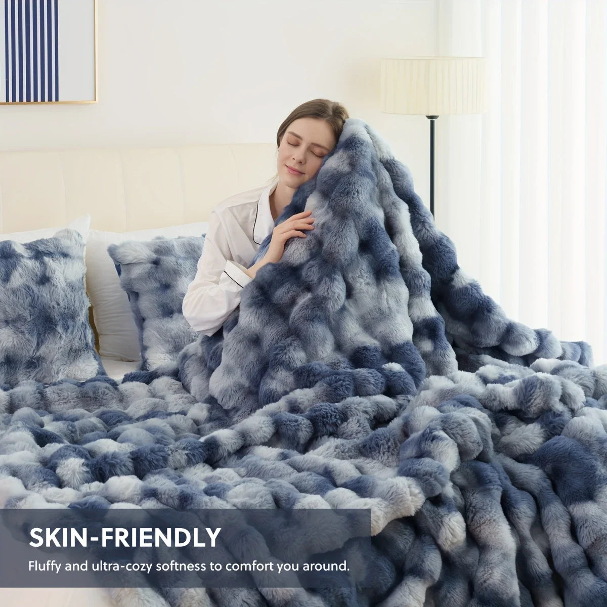 Flauschiges blaues Kunstfell-Kaninchen-Fleece-Decke über einem Bett, die seine weiche und gemütliche Textur betont.