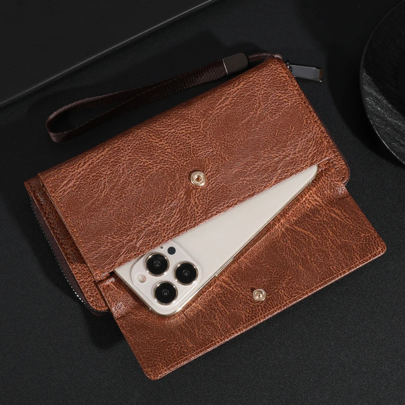 Portefeuille clutch en cuir marron avec un couteau argenté visible à l'intérieur, posé sur une surface sombre.