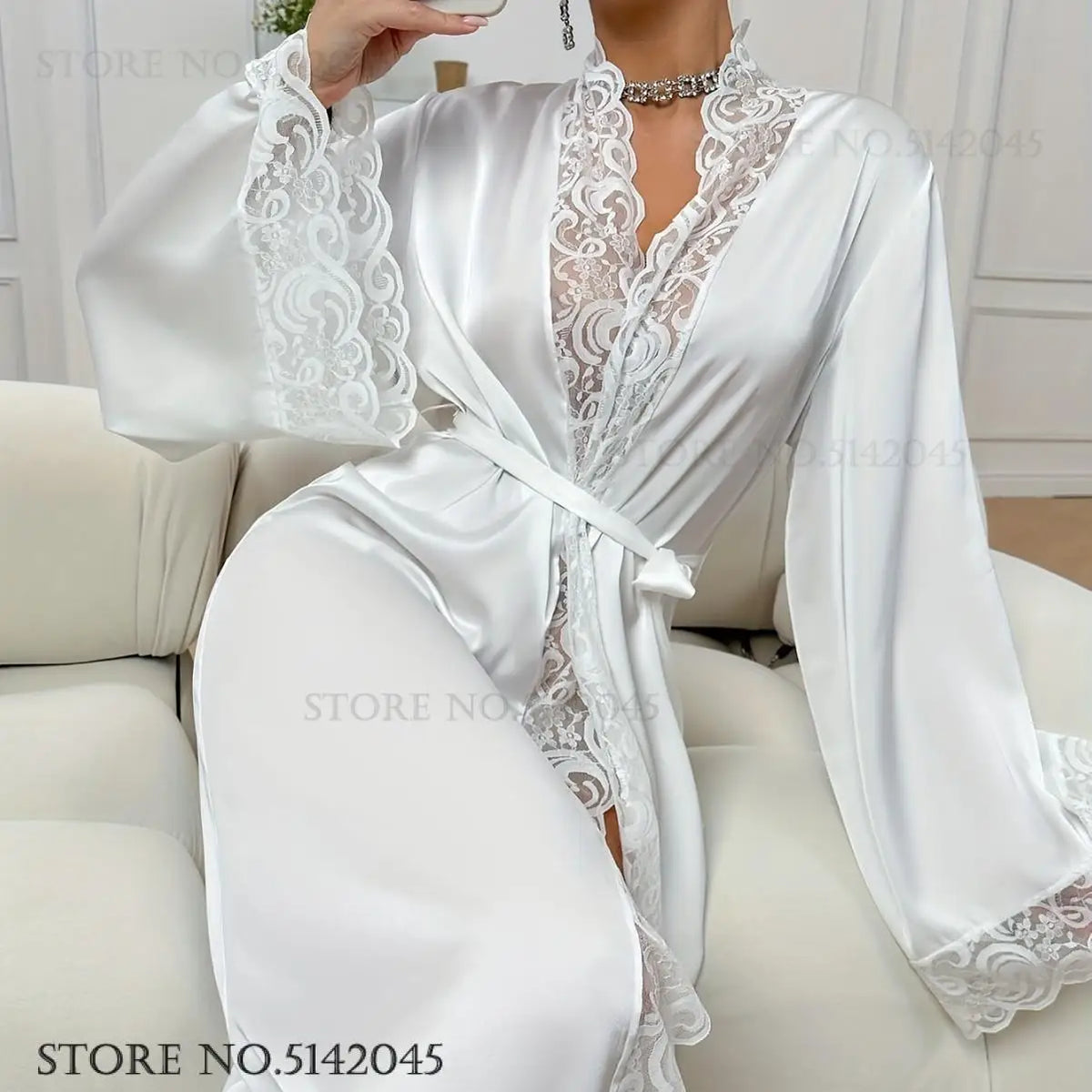 White silk satin robe with lace trim and tie belt worn by a model.