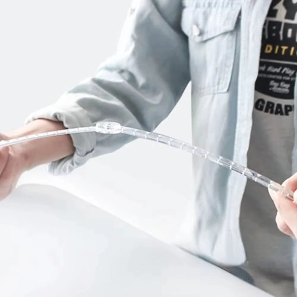 A hand is holding a clear, flexible plastic ruler used for measuring.