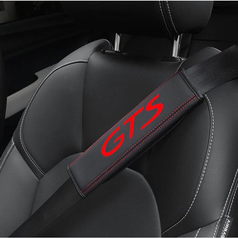 A black leather seat belt cover with GTS branding is shown on a car seat.