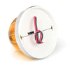 A round white light housing with an orange lens and a pink electrical wire visible inside.