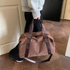 A brown leopard print duffle bag with adjustable straps is held by a person in a modern interior setting.