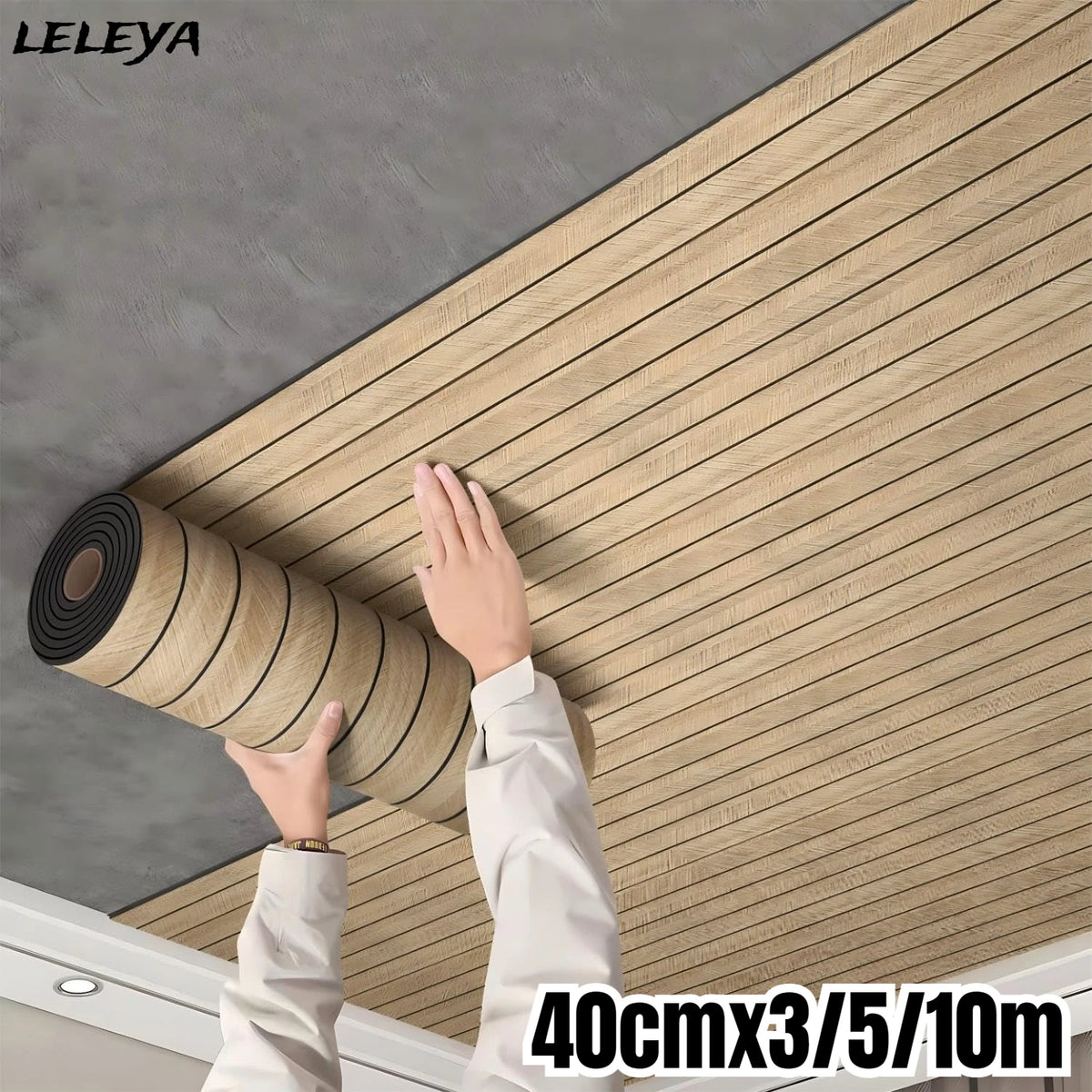 A hand is applying a roll of wood grain wall panels onto a gray wall surface.
