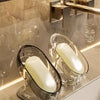 Elegantes, leichtes Glas-Seifenschale mit einer weißen Seife auf einer goldfarbenen Arbeitsplatte.