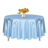 A round table set with a light blue satin tablecloth and a vase of yellow flowers.