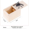 A wooden box containing a black spider model, made of wood and soft rubber.