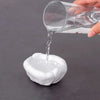 A hand pours clear liquid from a glass into a white moldable sealing clay for AC holes or pipe gaps.