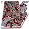 Close-up view of pink glitter African wax print fabric with intricate floral patterns and geometric designs