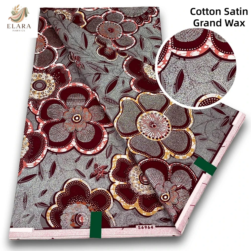 Close-up view of pink glitter African wax print fabric with intricate floral patterns and geometric designs
