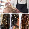 A person is using a plastic latch hook needle set to style dreadlocks or crochet work.
