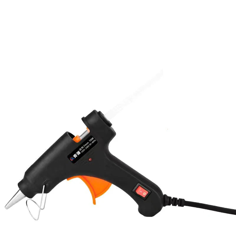 Black hot melt glue gun with orange handle and glue sticks